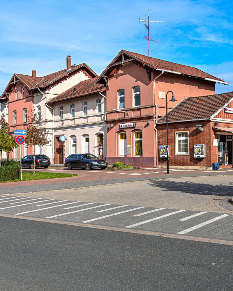 Das Bahnhofsgebäude in Walsrode in einer Frontalansicht mit Sicht auf den Bahnhofsvorplatz