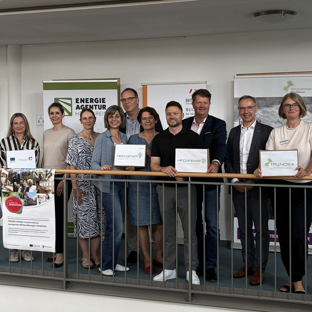| Ⓒ Deltaland Elf Personen stehen nebeneinander für ein Gruppenfoto bei einem Pressetermin.