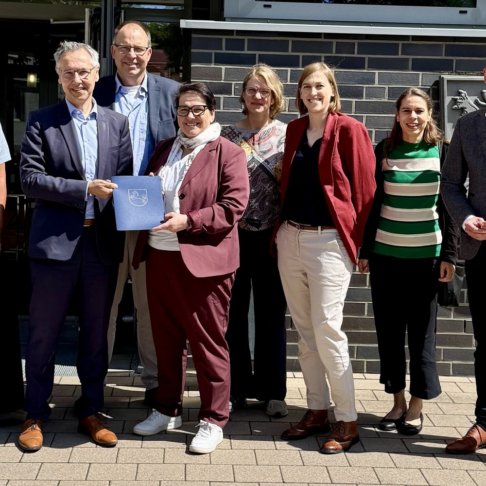 | Ⓒ Deltaland Das Foto ist ein Gruppenbild von 8 Personen bei der Übergabe eines Fördermittelbescheids. Zu sehen sind: Anke von Fintel (Landkreis Heidekreis), Landrat Jens Grote, Deltaland-Geschäftsführer Michael Krohn, Ministerin Melanie Walter, Dr. Theresa Weinsziehr (Energieagentur Heidekreis), Cornelia von Zengen (Landkreis Heidekreis), Stefani Thomas (Amt für regionale Landesentwicklung), Sebastian Zinke (Mitglied des Landtags)